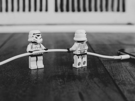lego storm troopers pulling the charging cable out of an iphone... or maybe putting it in?