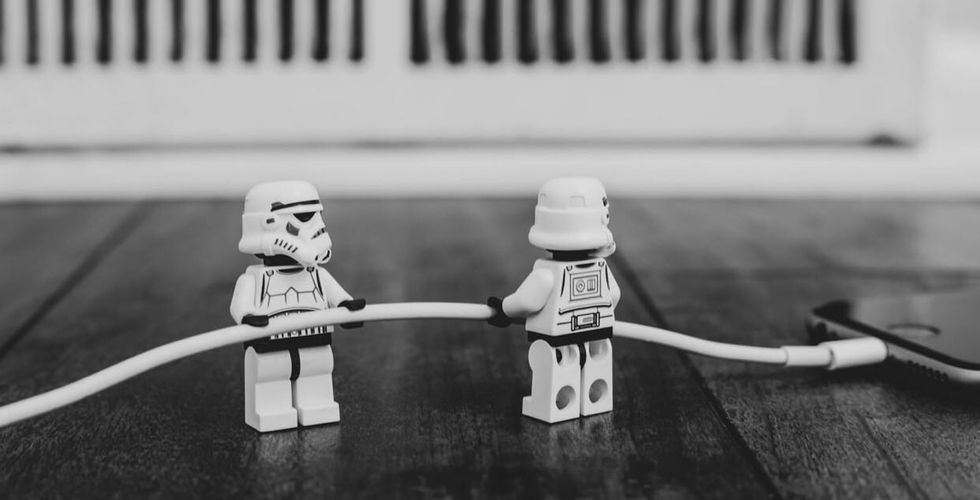lego storm troopers pulling the charging cable out of an iphone... or maybe putting it in?