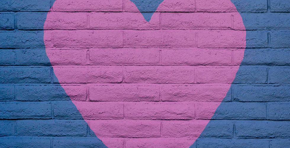 A pink heart painted over a purple brick wall outside representing the article "The Truth About Whether to Make Your Nonprofit Drupal Website Headless"