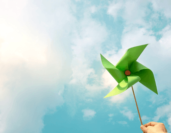 green pinwheel against a blue sky 
