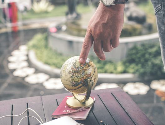 finger pointed to globe representing the article Tricks to Make your Gatsby Localization Project a Success