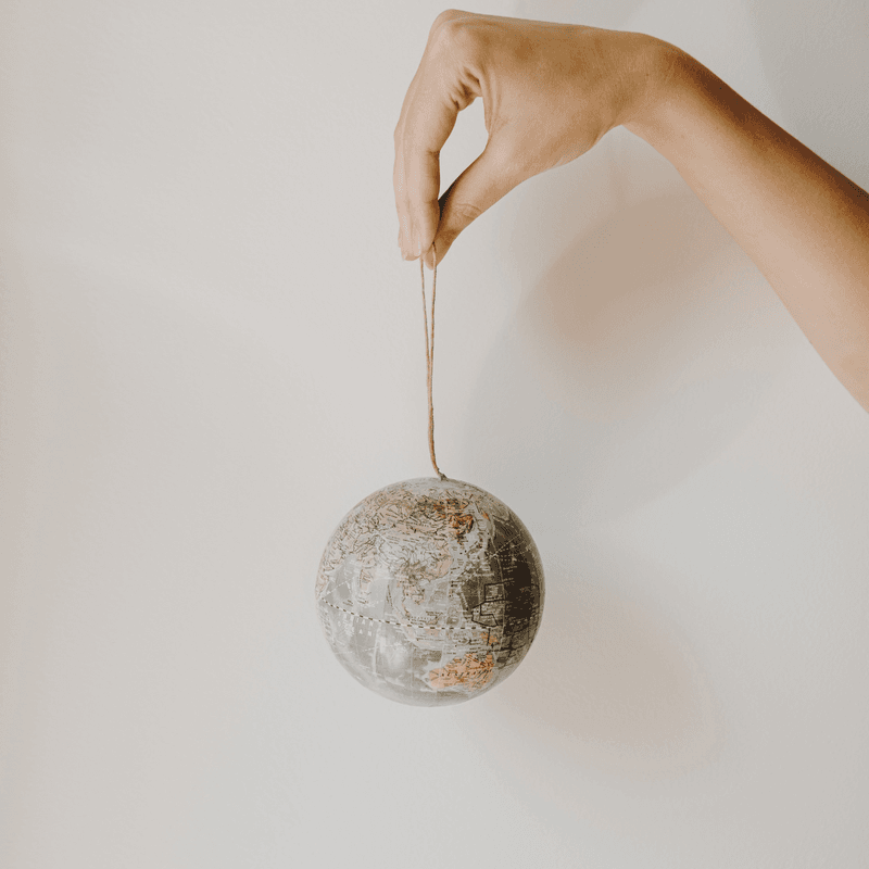 Hand holds small globe on a string