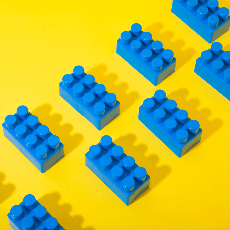 blue building blocks arranged on a yellow background 