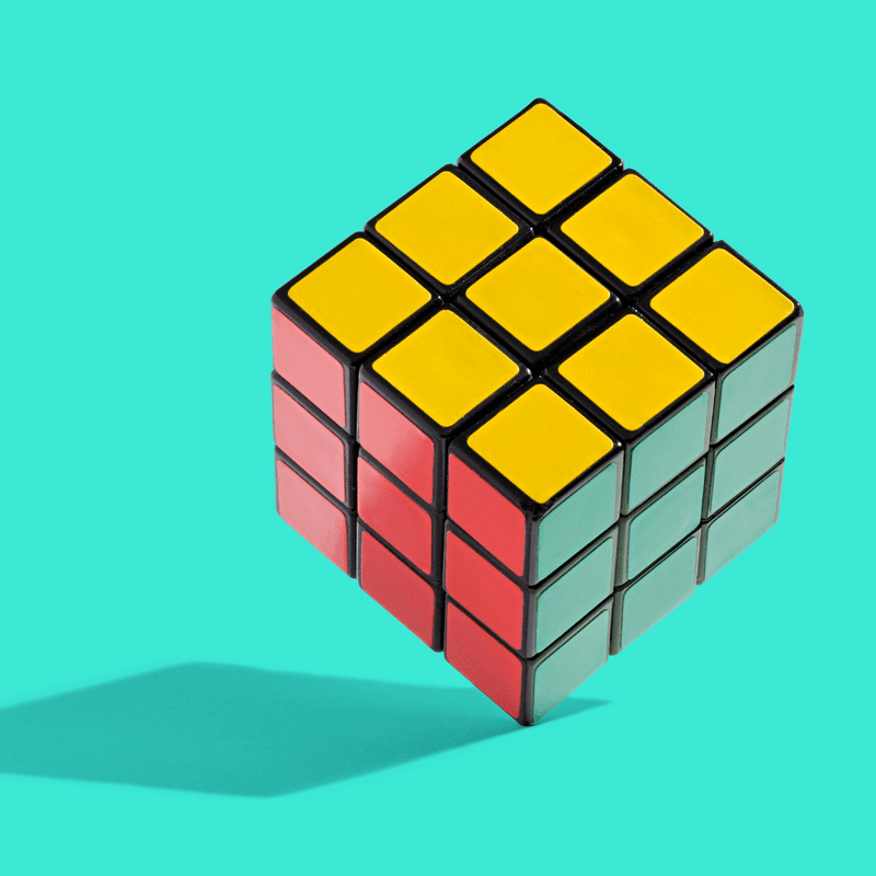 completed rubix cube on a teal background 